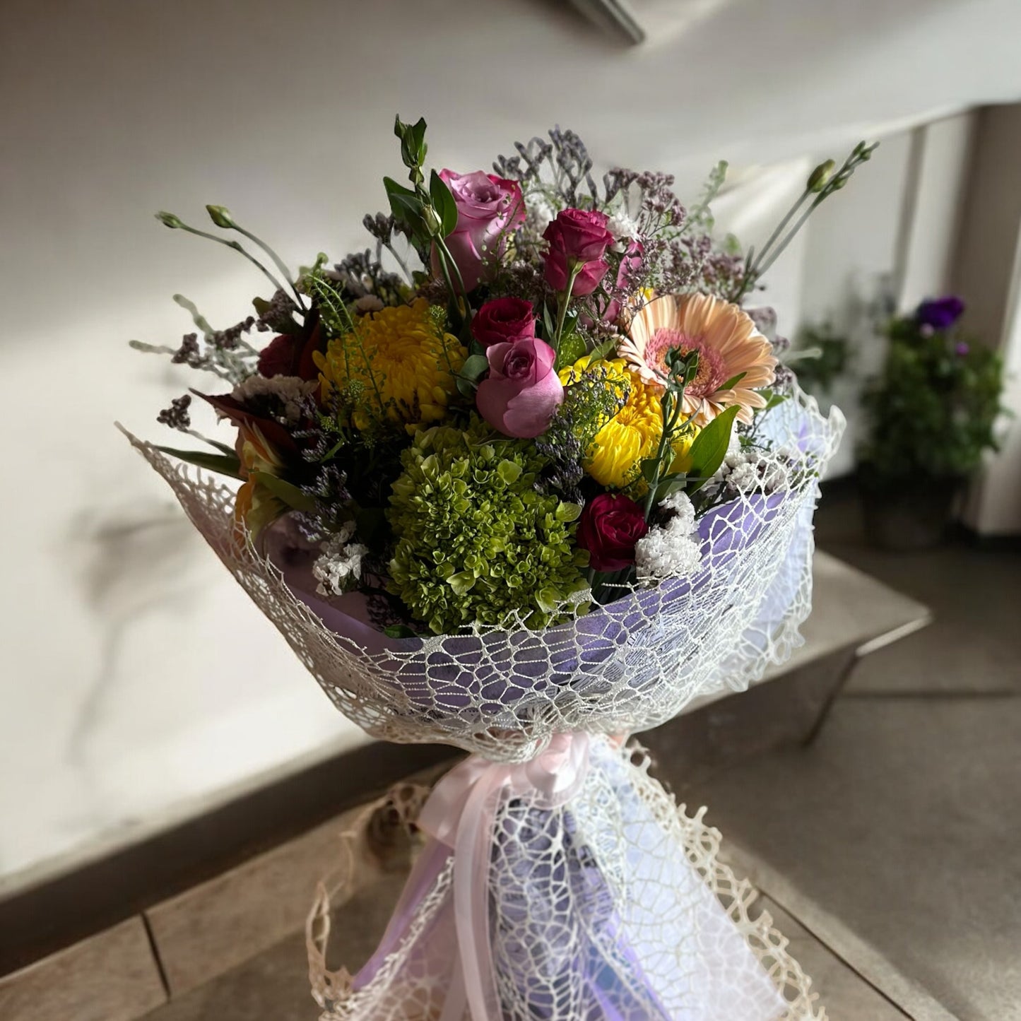 Pastel-colored spring bouquet featuring soft pink peonies, roses, and delicate filler flowers