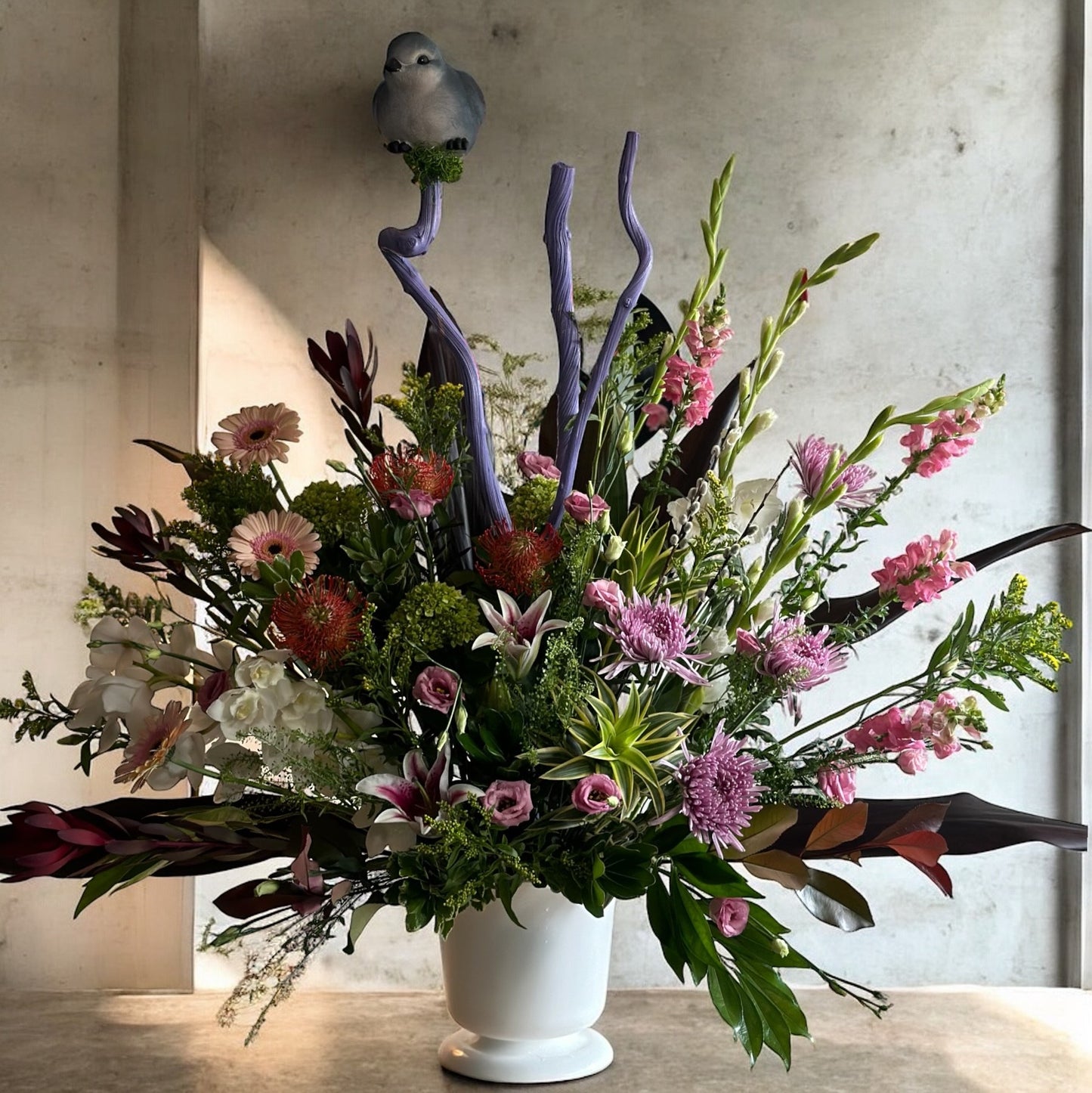 Classic sympathy flower basket featuring white lilies, hydrangeas, and soft greenery, offering warmth and condolence.