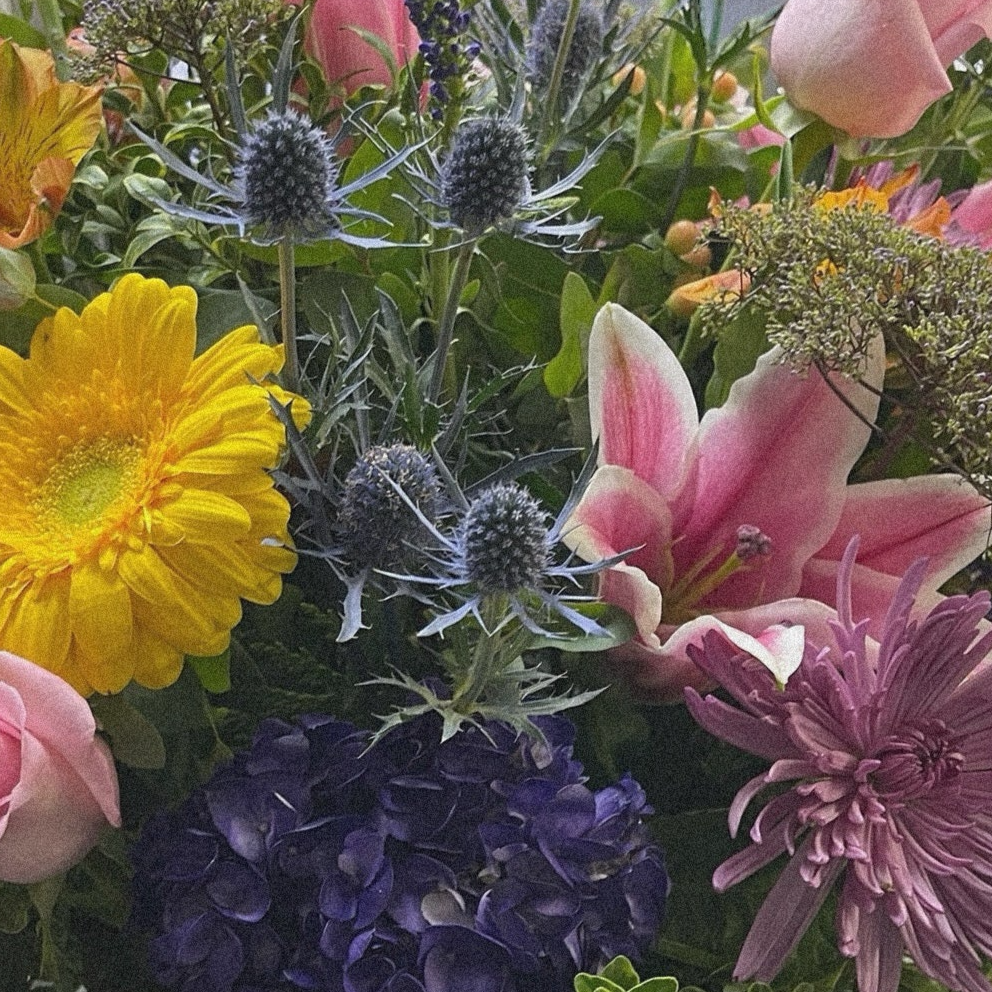 Joyful Symphony luxury flower arrangement with yellow gerbera daisies, pink roses, and purple blooms; same day delivery in Toronto and GTA.