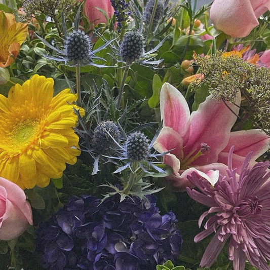 Joyful Symphony luxury flower arrangement with yellow gerbera daisies, pink roses, and purple blooms; same day delivery in Toronto and GTA.