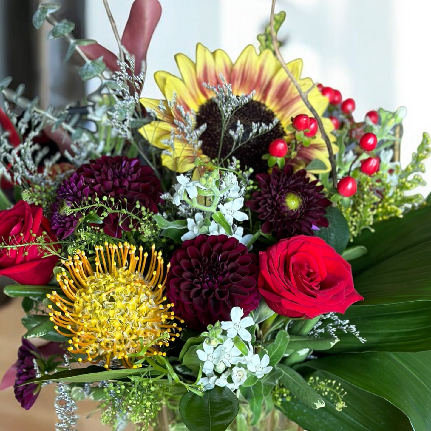 Luxurious floral bouquet with red roses, burgundy dahlias, and bright yellows; best Toronto florist offers same-day delivery.