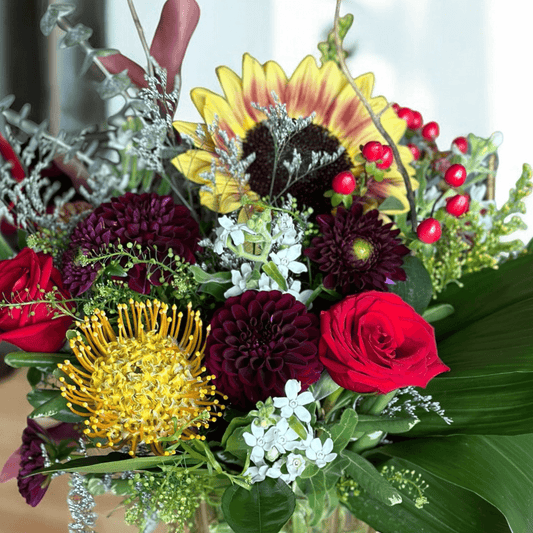 Luxurious floral bouquet with red roses, burgundy dahlias, and bright yellows; best Toronto florist offers same-day delivery.