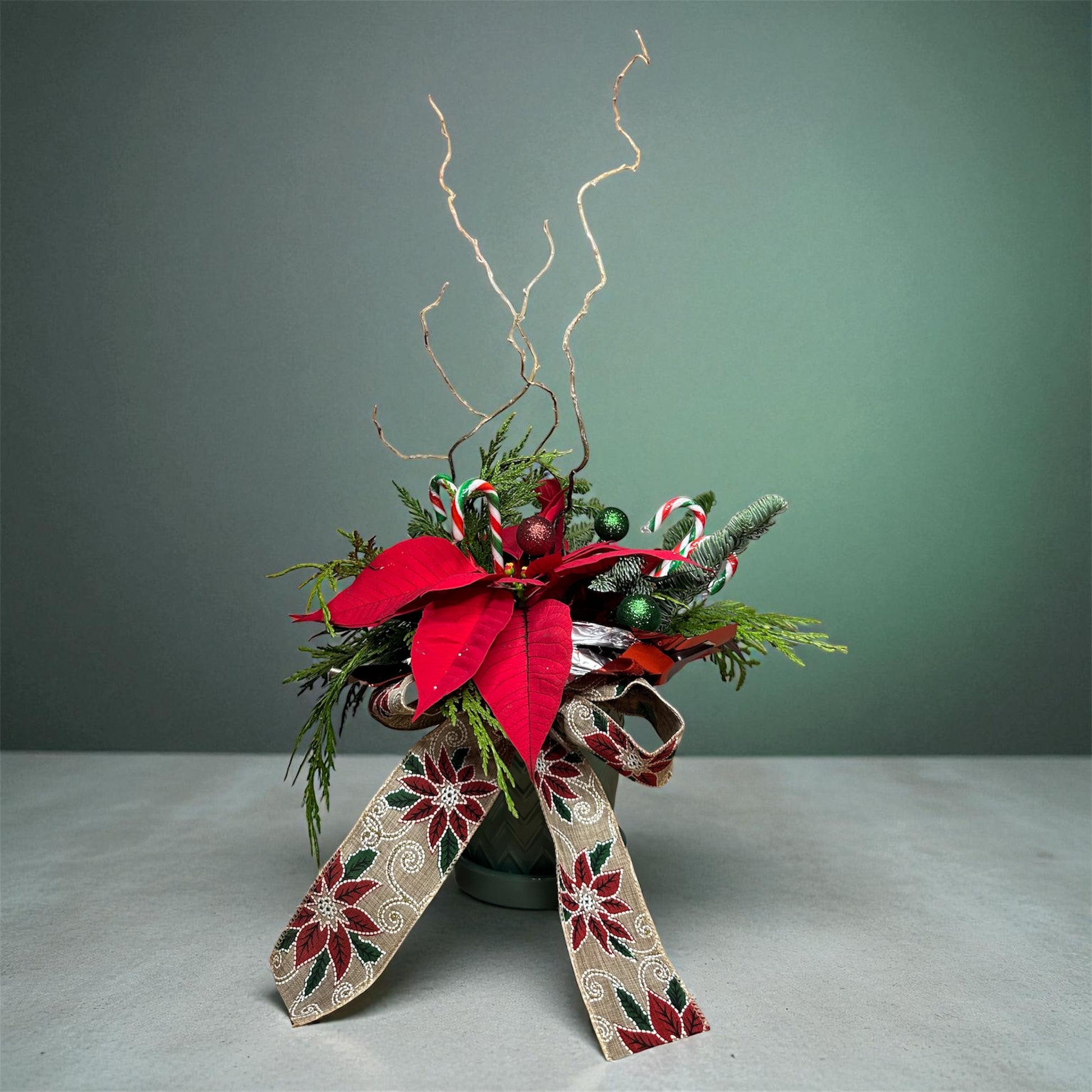 Holiday Poinsettia Candy Bowl with red poinsettias, candy canes, glitter ornaments, and poinsettia ribbon as a festive centerpiece.